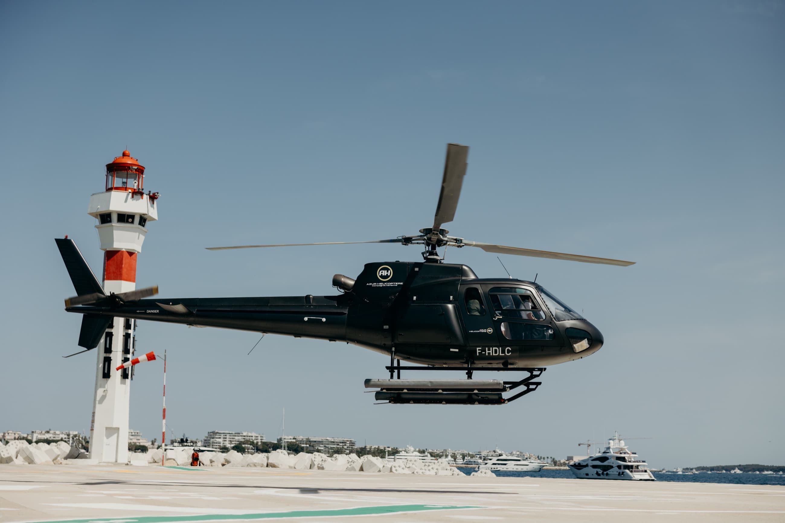 A private helicopter lifting off over the coast at Cannes